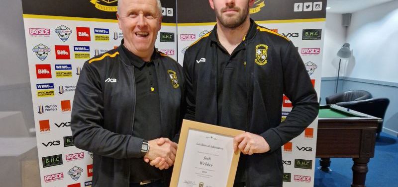 Josh Webber being presented with an award for passing 100 games for Buckland Athletic